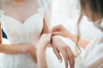 The bridesmaid helps to wear bracelet  for bride