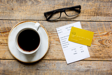 paying check for lunch with card wooden table background top view