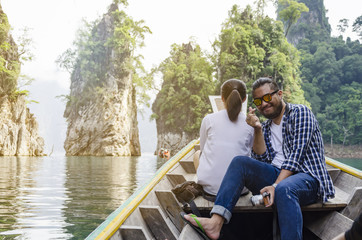 Man enjoying to adventure trip of a lifetime floating in a boat on the asia lake.
