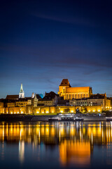 Fototapeta na wymiar Torun's Old Town panorama with its reflection in Vistula river at the evening