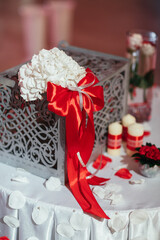 Little white table decorated with petals and grey chest on it