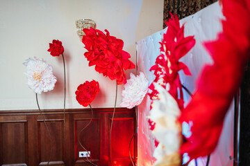 Wall decorated with red flowers stands in the corner of a hall