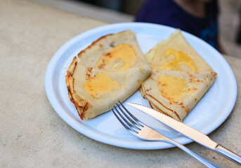 Plate with two pancakes with butter served on white plate