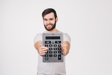 unshaved man in white t-shirt shows a big calculator