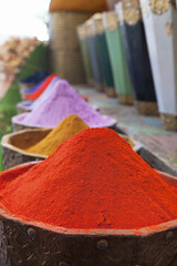 Vertical shot of natural dyes, colorful and vibrant pigment powders in wooden pots
