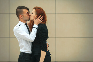 Couple in love. Handsome guy and pretty girl posing opposite modern urban background.