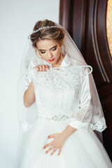 Happy bride looks at gorgeous wedding dress