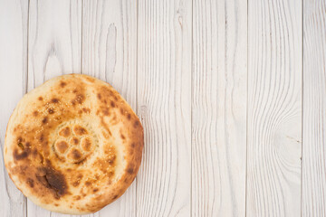 Uzbek bread on old white wooden table.