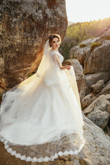 Golden sun illuminates stunning bride posing on the hill