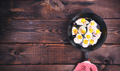 fried quail eggs in a cast-iron black frying pan