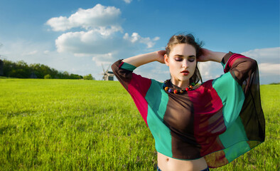 Young beautiful girl with long dark hair in green field in outdoor ethnic village Pirogovo in Kiev Ukraine