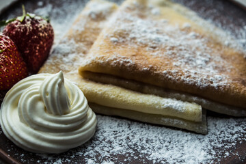 Pancakes with strawberries powdered sugar and cream