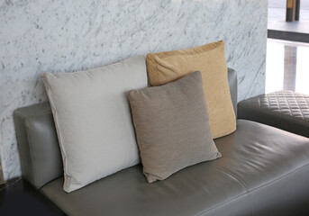 Fabric pillows on leather sofa.