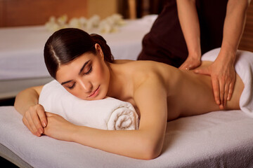 Beautiful woman lying in spa massage salon.