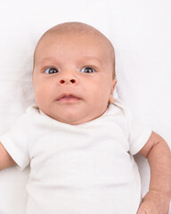 Newborn baby on white sheet