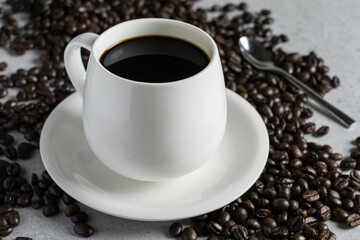 White glass of coffee with coffee bean on a stone table.