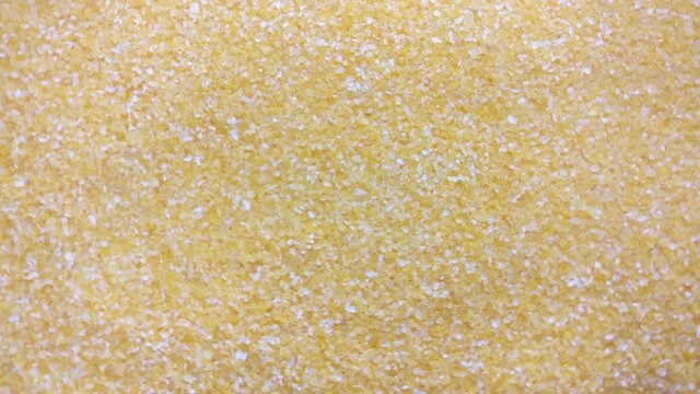 Great background of Dried milled corn grains (Corn groats) are rotating close up.  Footage will work great for any videos dealing with cooking, health nutrition and much more.
