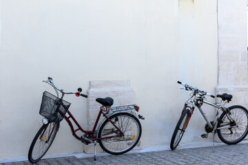 Fototapeta na wymiar Two bicycles stand at a white wall