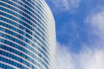 Obraz premium Modern blue glass wall of skyscraper. Business building, office center. Abstract architecture, fragment of modern urban geometry. Background lines