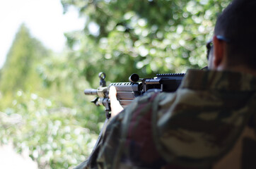 Soldier aim target in forest rifle gun sight