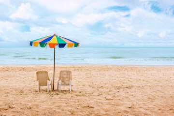 Two chairs and beach umbrella on the beach with nice sky and cloud at noon time.Holiday concept, relaxation