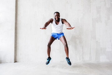 Bearded african athlete showing enormous effort while jumping