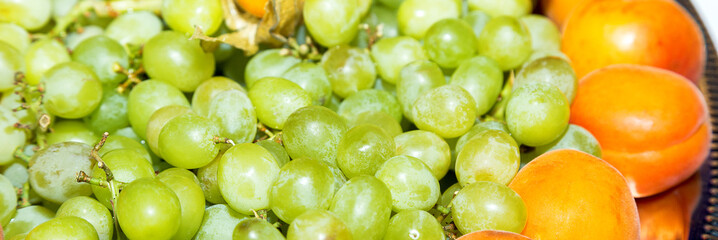 Green grapes and peaches lie on a tray