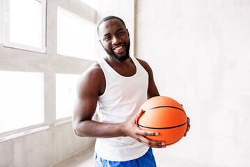 Cheerful bearded athlete training with ball