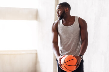 Pensive muscular african man playing basketball