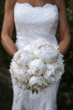 bride holding bouquet with white roses