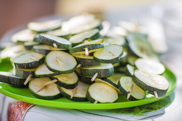 Plate full of zucchinis on grill sticks.