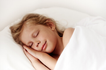 Adorable little girl sleeping in comfortable white bed in the room. Child healthy dream. 