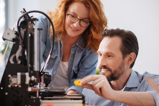 Delighted positive man holding a 3d printer detail - Powered by Adobe