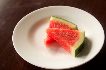 Slice of delicious watermelon on white plate background