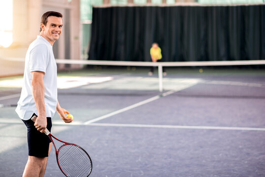 Cheerful guy enjoying tennis game
