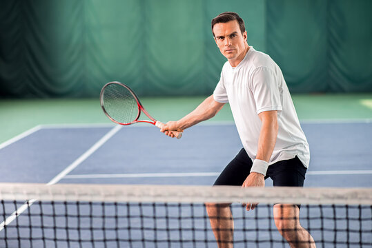 Confident man holding tennis racket