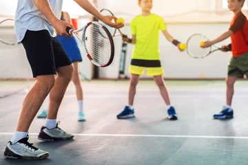 Tuinposter Professional tennis player teaching kids © Yakobchuk Olena