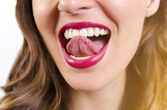 Young woman with perfect teeth, sticking tongue out / teeth whitening 