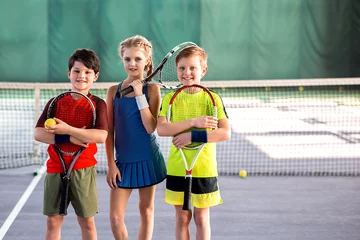 Poster Girl and boys playing tennis with enjoyment © Yakobchuk Olena