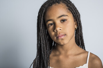 Adorable sad african little girl on studio gray background
