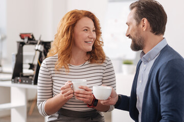 Happy delighted colleagues having coffee