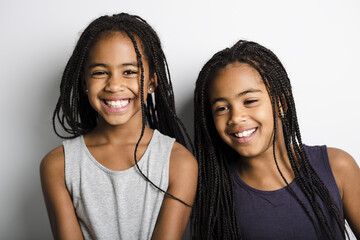Adorable african twin little girls on studio gray background - obrazy, fototapety, plakaty