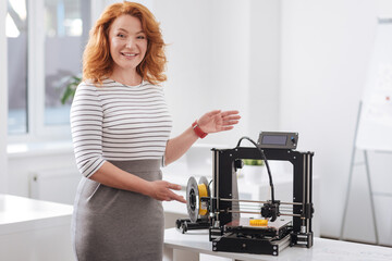 Fototapeta na wymiar Good looking attractive woman showing you a 3d printer