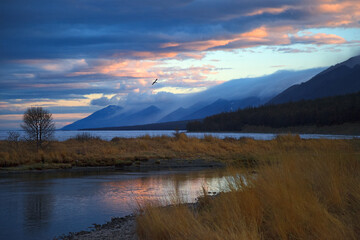 Sunset over mountain lake in blue and pink colors, scenic romantic landscape