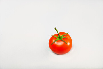 red tomatoes with green branches on a light background isolate