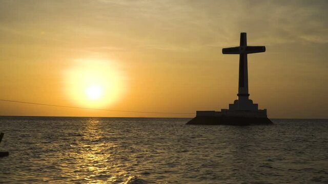 Sunken Cemetery cross in Camiguin Island, Philippines. Large crucafix marking the underwater sunken cemetary of the coast of camiguin island near mindanao in the Philippines. Catholic cross in the