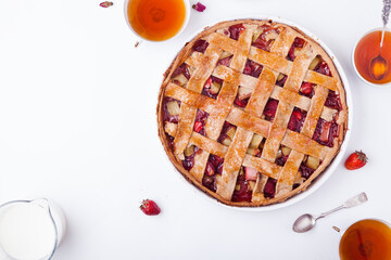 Toasted rye rhubarb pie with strawberry on white background with copy space. Summer tea time...