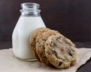Chocolate Chip Cookies Leaning Against Jar of Milk