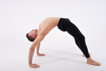 Yoga, aerobics and healthy lifestyle. A young sexy man doing stretching.