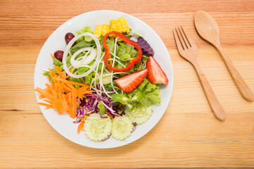 Fresh healthy salad on wooden table. View from above with copy space